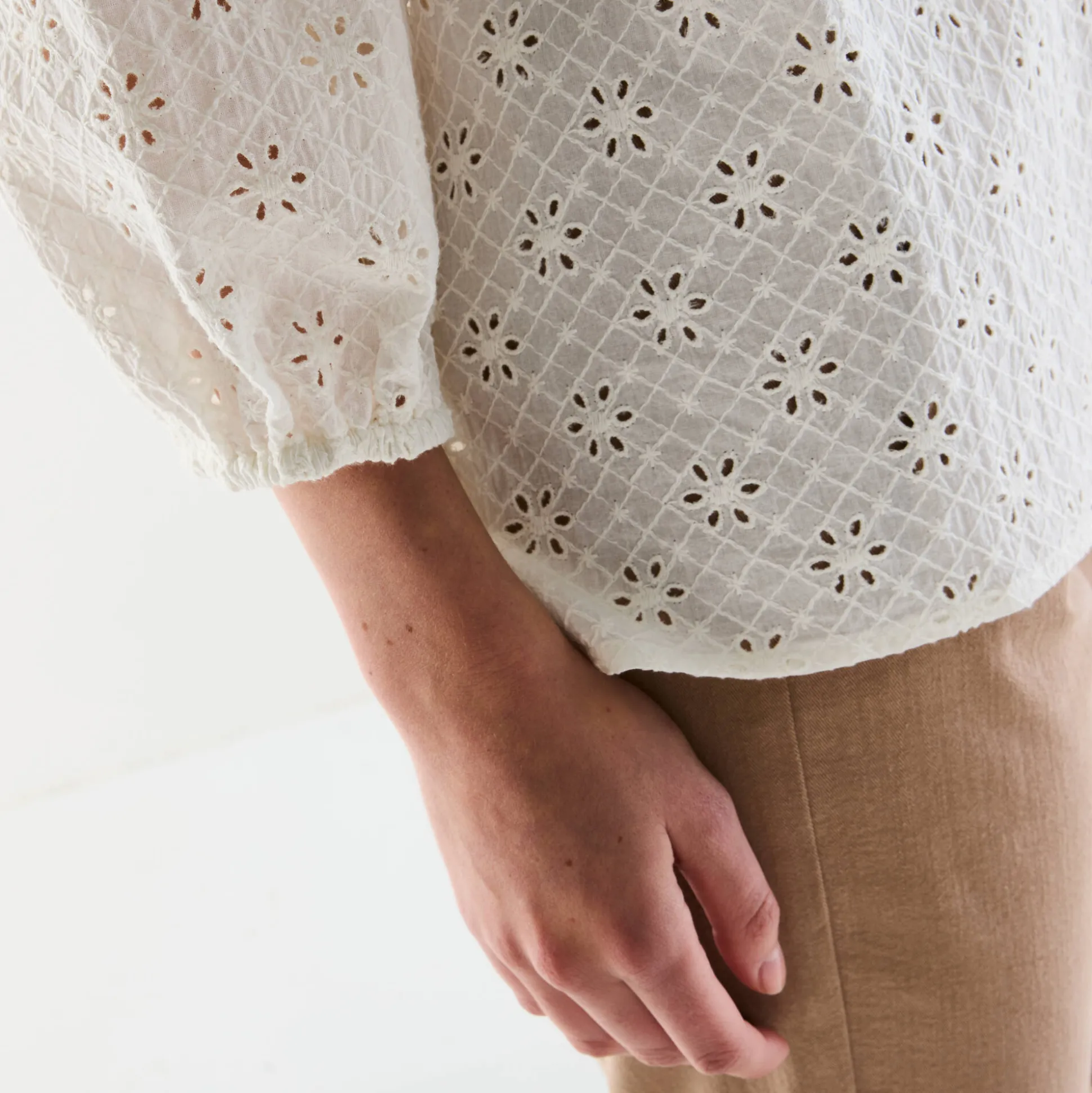Bloes met broderie anglaise, smokwerk en stroken aan de hals